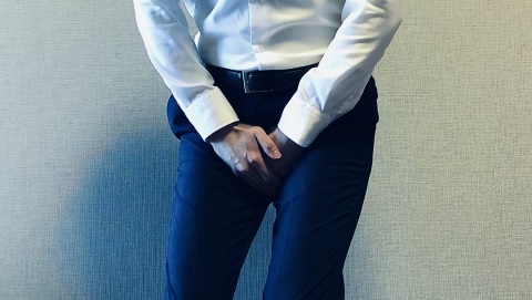 股間をおさえる男性